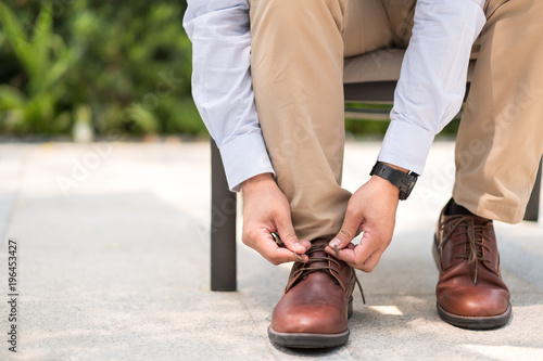 Businessman with leather shoes tying shoe laces, get ready to work or go outside