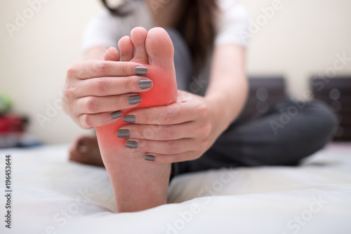 Young woman massaging her pain foot. Health care concept