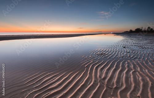 Long expose seascape with stunning sunset colors and natural sand pattern. 