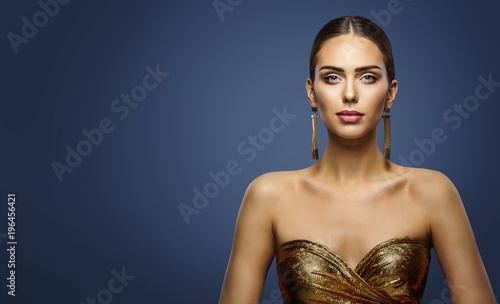 Fashion Model Beauty Studio Portrait, Beautiful Woman Face Makeup, attractive Girl in Golden Dress looking at camera, on Blue Background