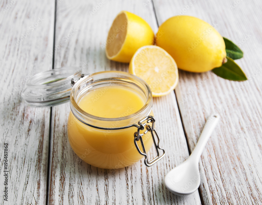 Lemon curd in glass jar with fresh lemons Lemon curd in glass jar with fresh lemons
