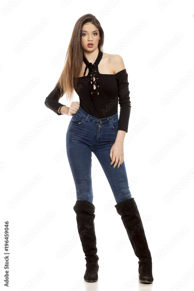 young woman in jeans and leather boots on white background young woman in jeans and leather boots on white background