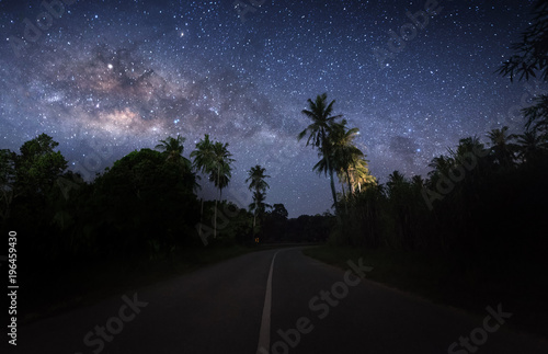 milkyway galaxy rise above coconut trees. image contain soft focus and noise due to long expose.