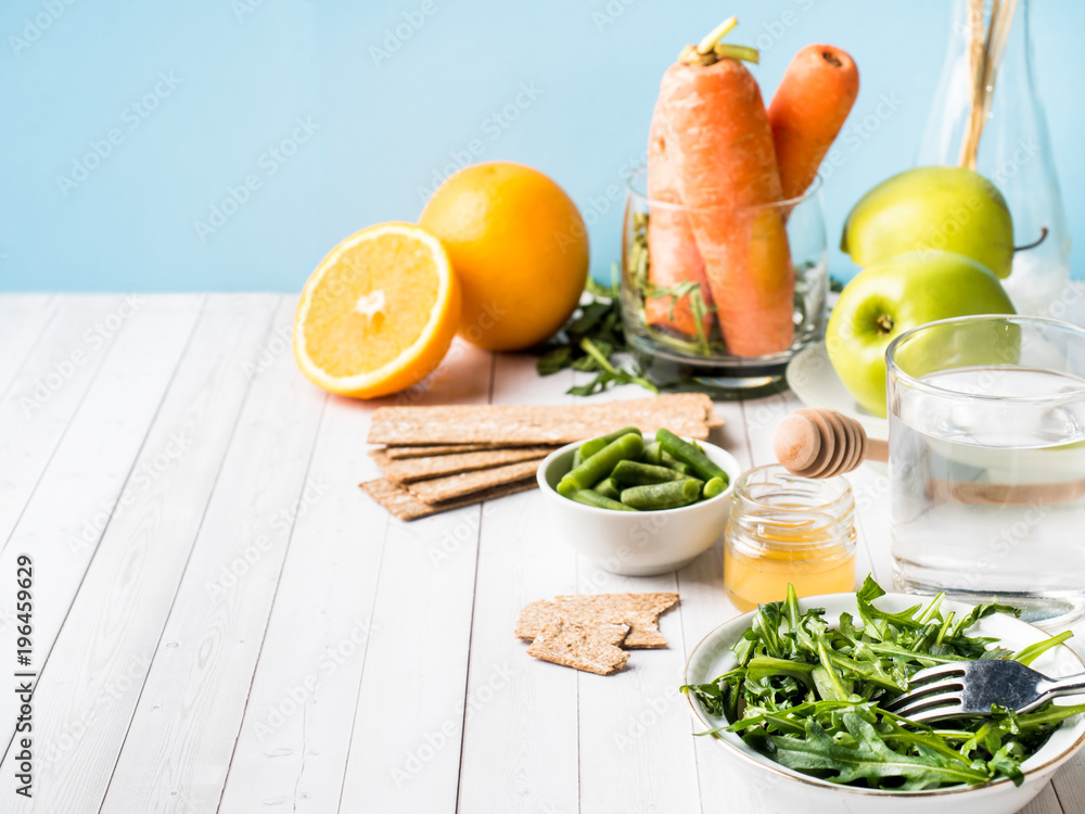 Healthy diet food on the table Arugula Green Beans Apple Water Honey Cracker Carrot Orange Copy space. Healthy diet food on the table Arugula Green Beans Apple Water Honey Cracker Carrot Orange Copy space.