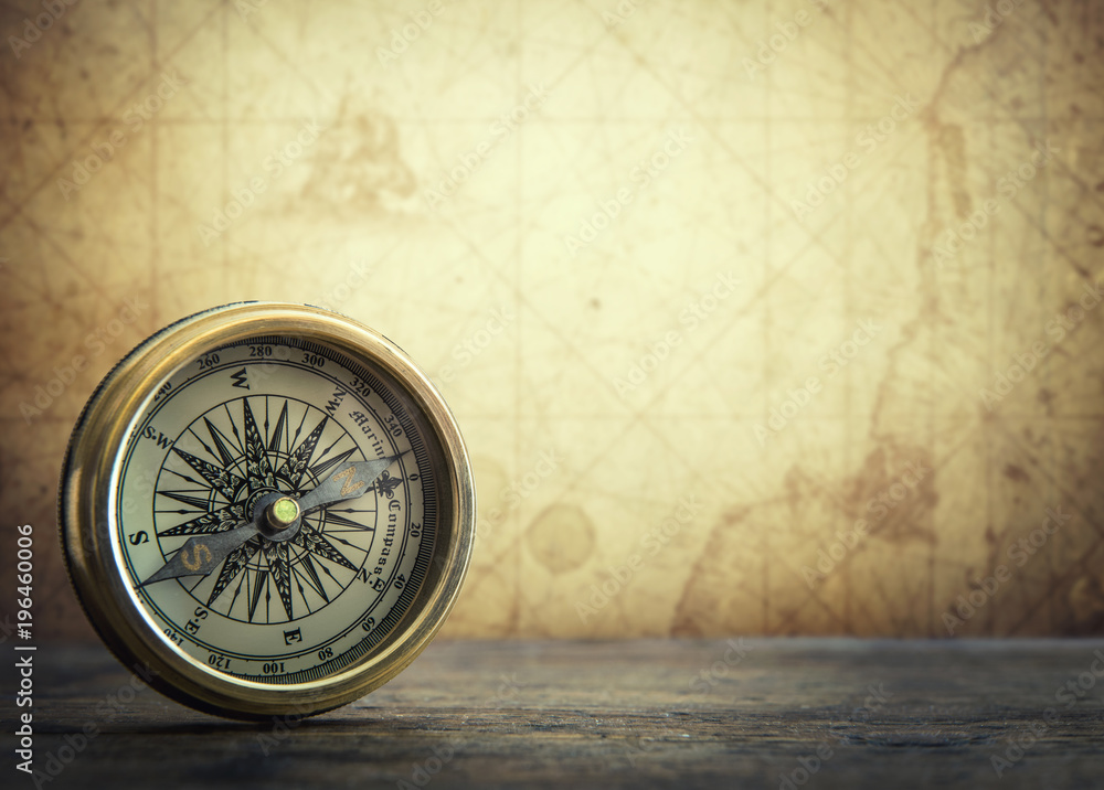 Fototapeta premium Old vintage retro compass on ancient map background. Travel geography navigation concept background.