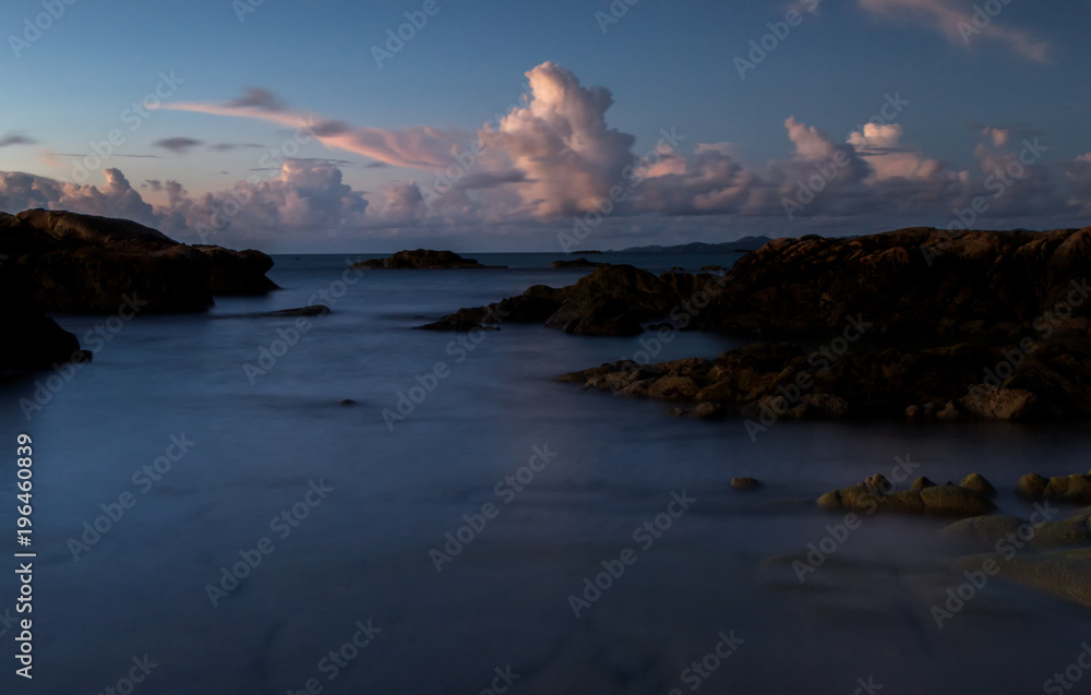 Fototapeta premium Serinity view of sunset seascape with natural coastal rocks on the beach.