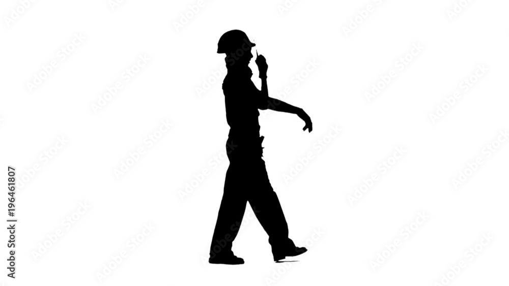 Engineer girl in glasses is walking along the street and talking on the walkie talkie . Silhouette. White background. Side view Engineer girl in glasses is walking along the street and talking on the walkie talkie . Silhouette. White background. Side view