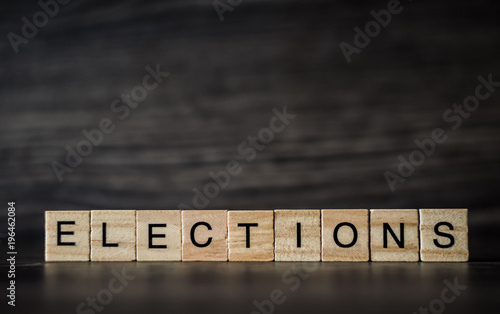 the word elections, consisting of light wooden square panels on a dark wooden background photo
