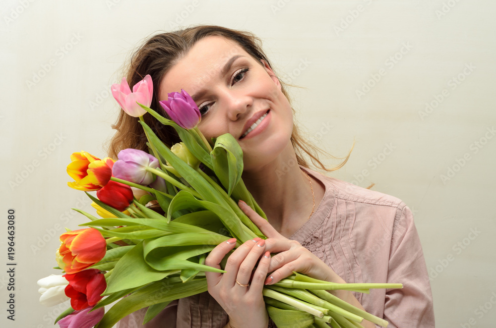 Young charming girl with a bouquet of flowers - multi-colored tulips Young charming girl with a bouquet of flowers - multi-colored tulips
