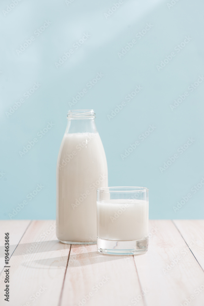 Dairy products. Bottle with milk and glass of milk on wooden table Dairy products. Bottle with milk and glass of milk on wooden table