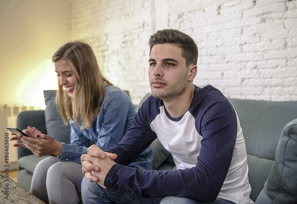 young couple at home sofa couch with woman internet and mobile phone addiction ignoring her boyfriend feeling sad jealous frustrated upset young couple at home sofa couch with woman internet and mobile phone addiction ignoring her boyfriend feeling sad jealous frustrated upset