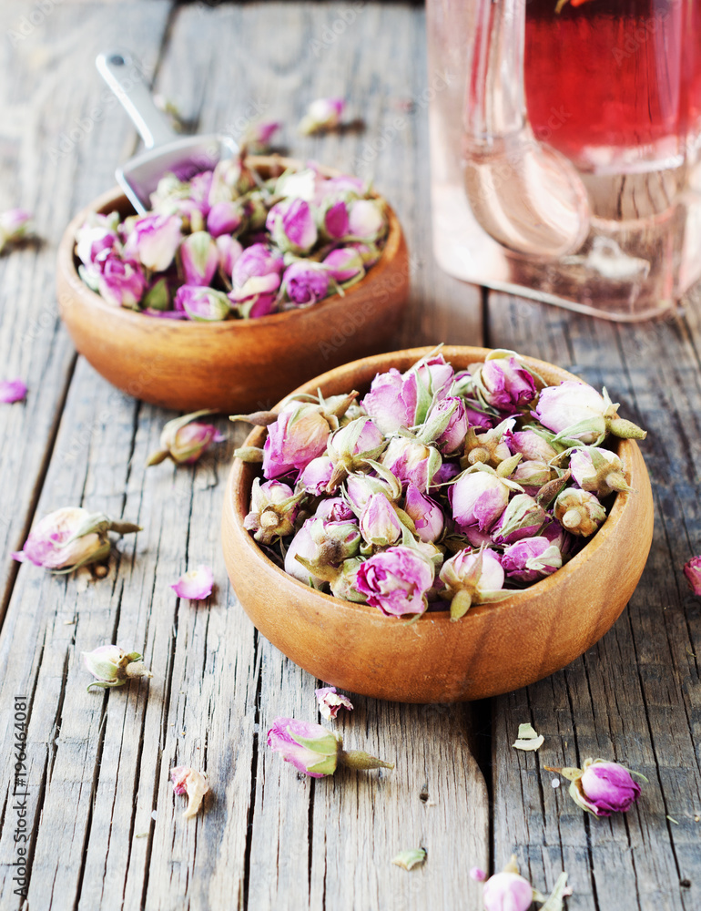 small dry buds of roses, tea, karkade, in wooden bowls, selective focus small dry buds of roses, tea, karkade, in wooden bowls, selective focus