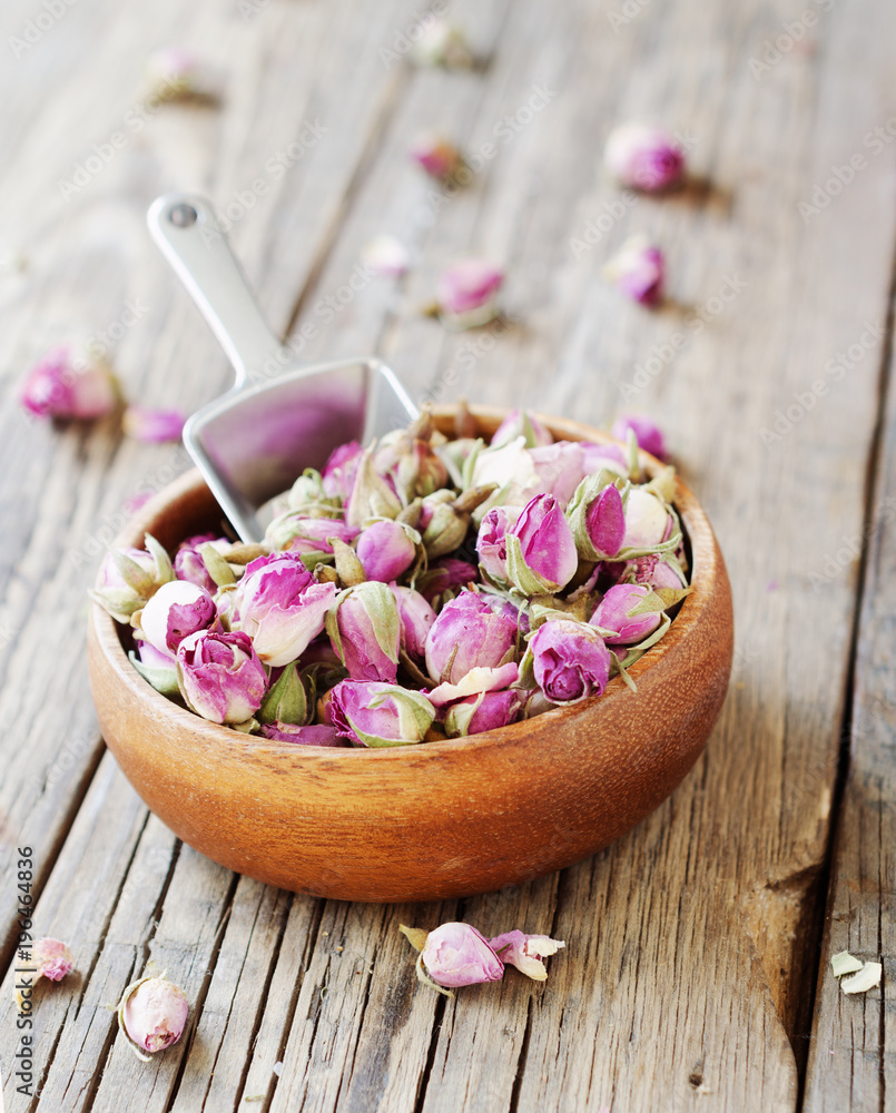 small dry buds of roses, tea, karkade, in wooden bowls, selective focus small dry buds of roses, tea, karkade, in wooden bowls, selective focus