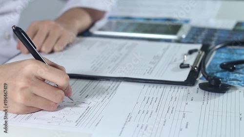 The doctor works in a modern private hospital. He looks at the x-ray of the patient in the medical office.