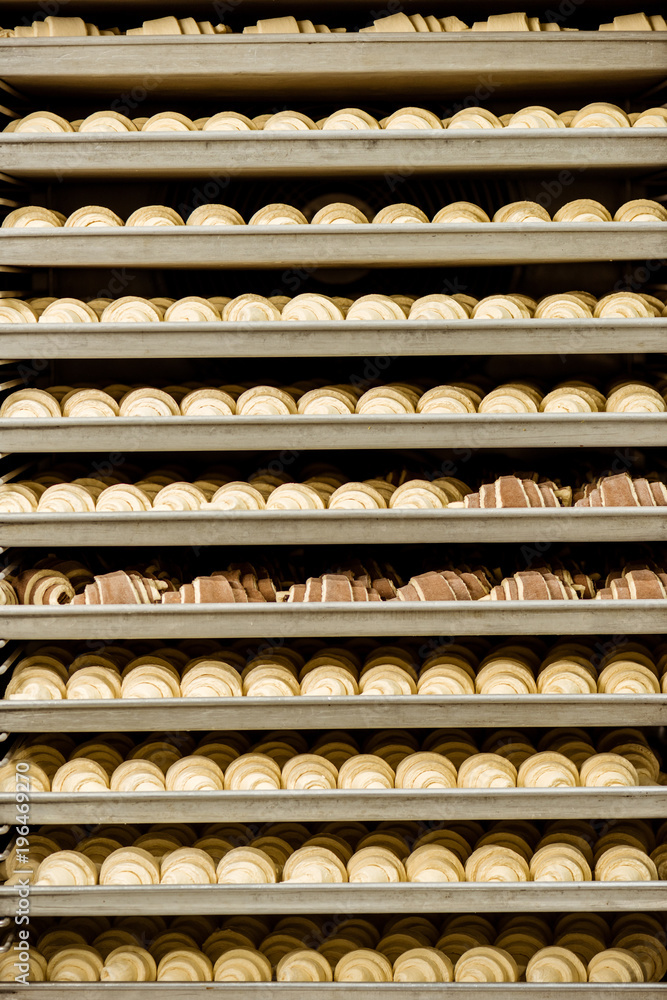 raw croissants on shelves in industrial oven