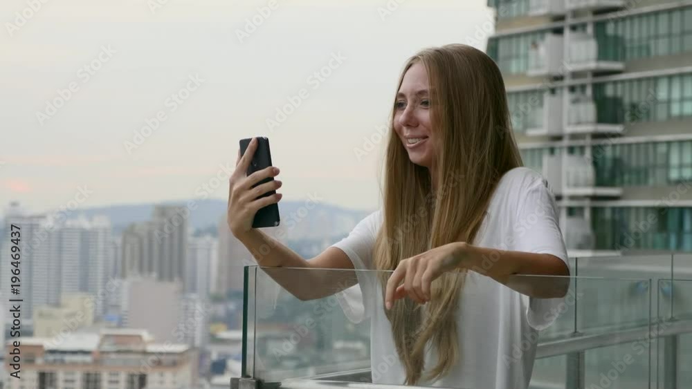 Young woman having video chat on holidays.Happy female tourist girl waving at webcam on mobile phone camera, sharing summer travel vacation adventure. Freedom,happiness,communication concept. Young woman having video chat on holidays.Happy female tourist girl waving at webcam on mobile phone camera, sharing summer travel vacation adventure. Freedom,happiness,communication concept.