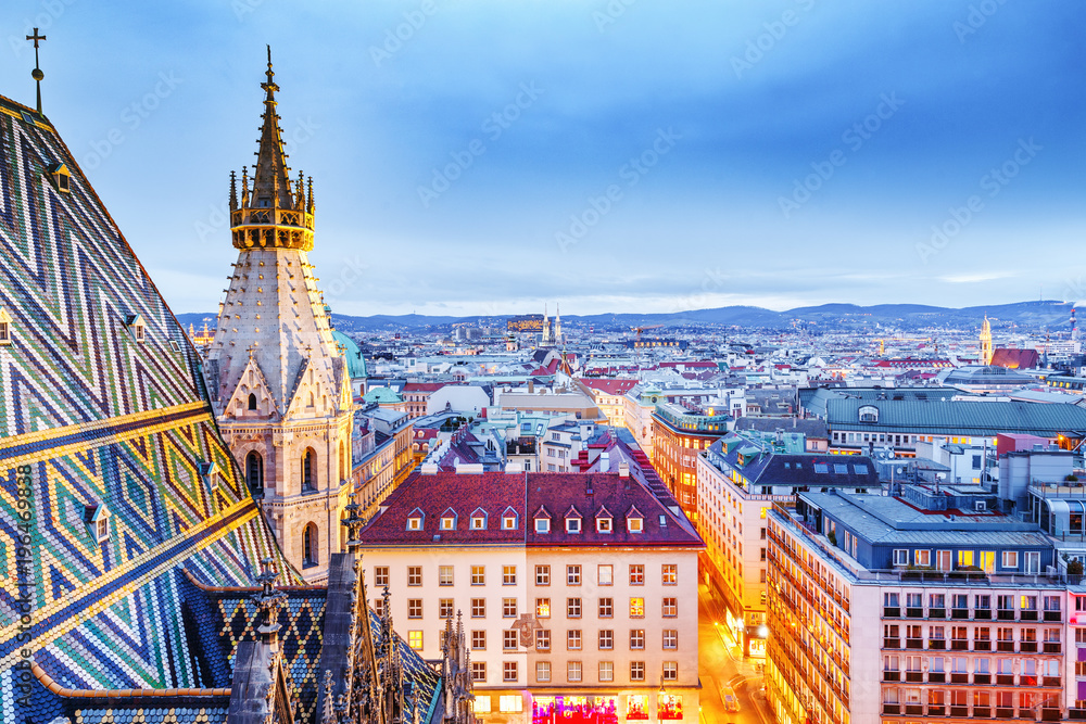 Vienna, Austria, Europe. Lovely twilight skyline view from above of Vienna. Iconic landmark and extremely popular European travel destination. View over roofs on classic architecture, dusk scenery.