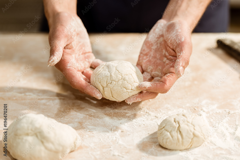 cropped shot of baker holding dough ball for pastry
