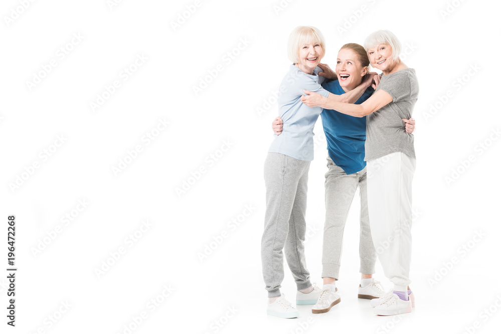 Three sportswomen embracing isolated on white Three sportswomen embracing isolated on white