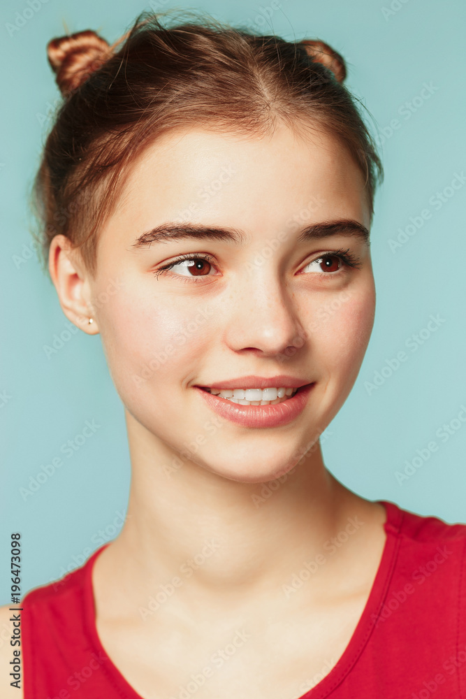 Woman smiling with perfect smile on the blue studio background and looking at camera Woman smiling with perfect smile on the blue studio background and looking at camera