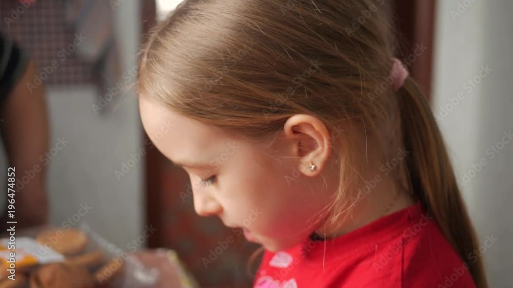 A little girl is drinking tea at the table. A little girl is drinking tea at the table.