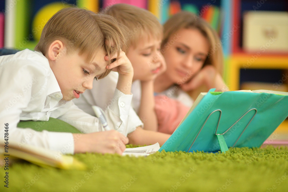Obraz premium mother and sons doing homework