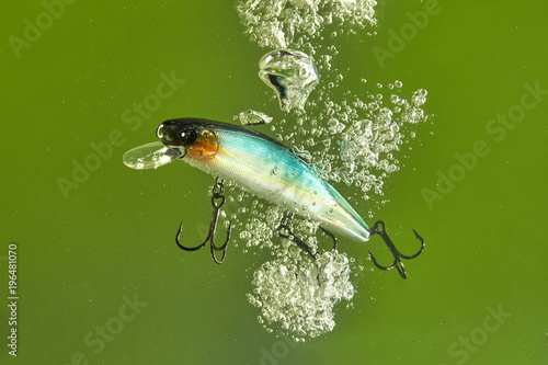 Hard lure under the water with splashes and bubbles.
