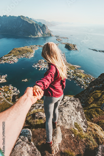 Couple follow holding hands traveling lifestyle on cliff mountain summer vacations outdoor in Norway