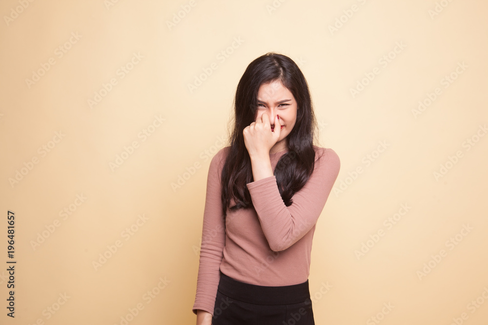 Young Asian woman holding her nose because of a bad smell. Young Asian woman holding her nose because of a bad smell.