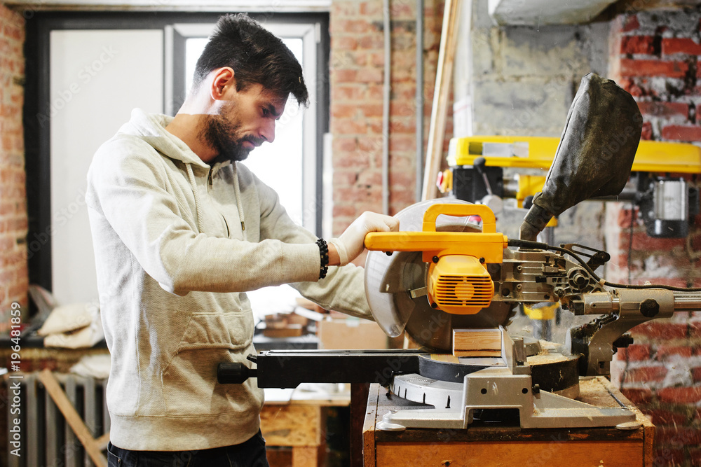 The young carpenter works in a workshop The young carpenter works in a workshop