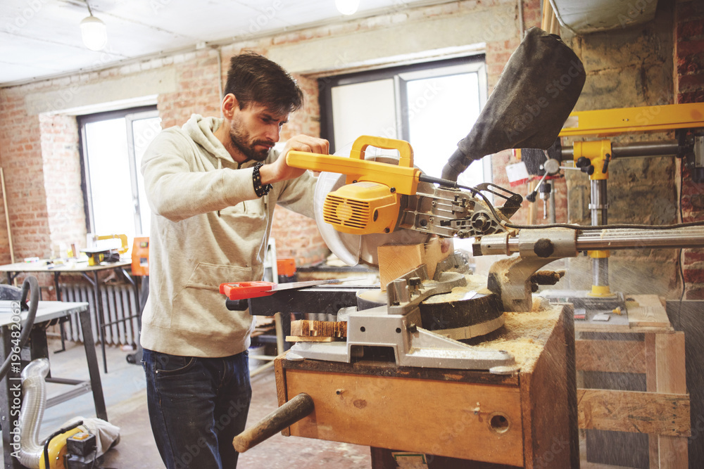 The young carpenter works in a workshop The young carpenter works in a workshop