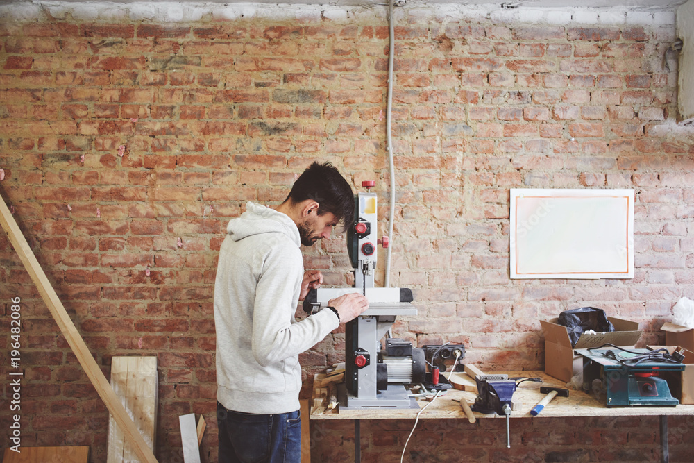 The young carpenter works in a workshop The young carpenter works in a workshop