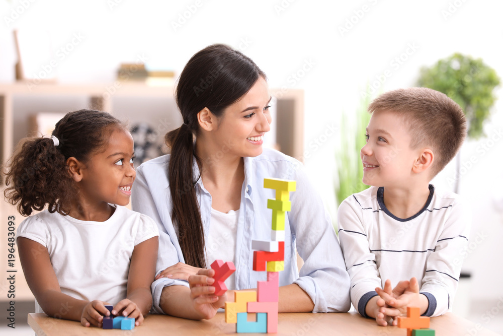 Young woman playing with little kids indoors. Child adoption Young woman playing with little kids indoors. Child adoption
