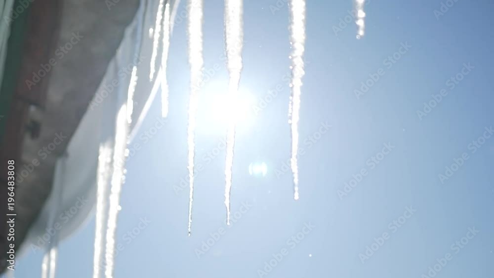 Many beautiful icicles melt on the roof at the end of winter and water drops are fall down. Spring is comming concept. Many beautiful icicles melt on the roof at the end of winter and water drops are fall down. Spring is comming concept.