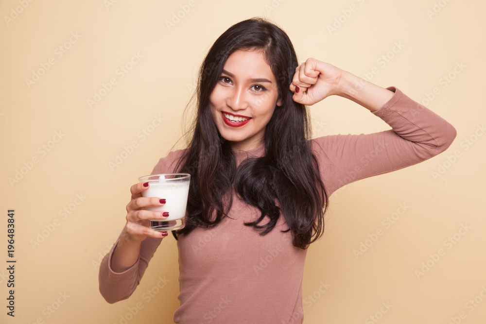 Healthy Asian woman drinking a glass of milk and dumbbell. Healthy Asian woman drinking a glass of milk and dumbbell.
