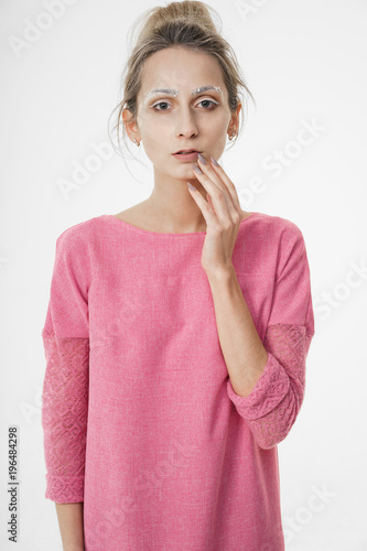 Beautiful sensual woman in pink touching face