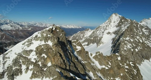 Group of Moutaineers and Religious Cross on Alps Mountain Peak photo