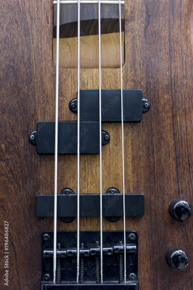 Body of a classic bass guitar.electric bass guitar element.Guitar neck closeup.Chord.selective focus. Body of a classic bass guitar.electric bass guitar element.Guitar neck closeup.Chord.selective focus.