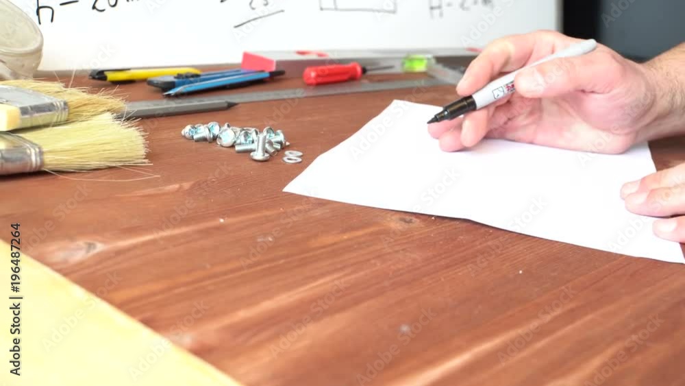 The master draws a picture on paper. Black marker. Body part. Dark wooden table. On the background instruments. The interior of the shop. Profession. 4K video The master draws a picture on paper. Black marker. Body part. Dark wooden table. On the background instruments. The interior of the shop. Profession. 4K video