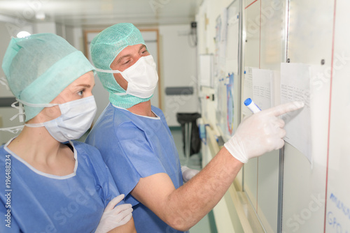 Quadro em tela Surgeons looking at schedule on board
