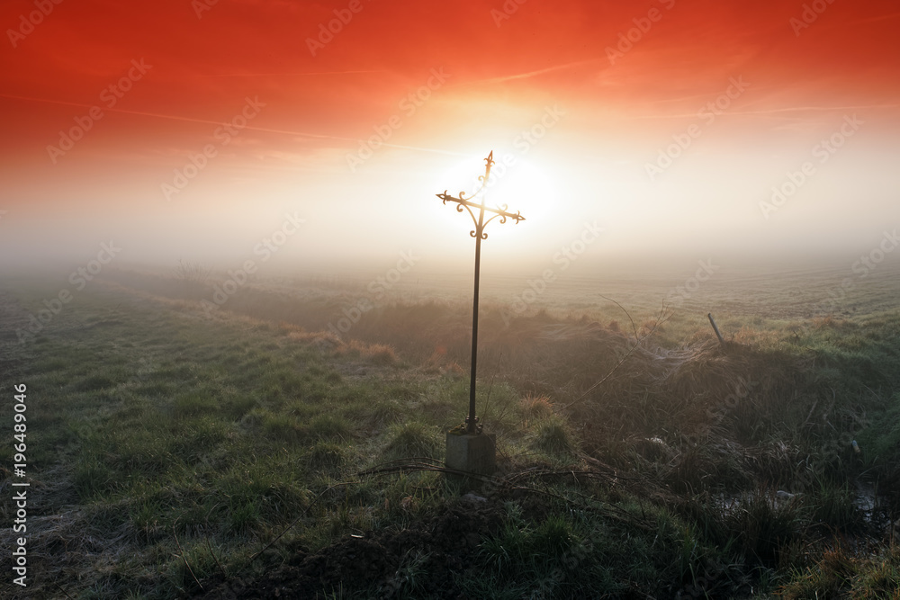 Obraz premium Wrought iron cross in misty field. Le Coudray-Montceaux village