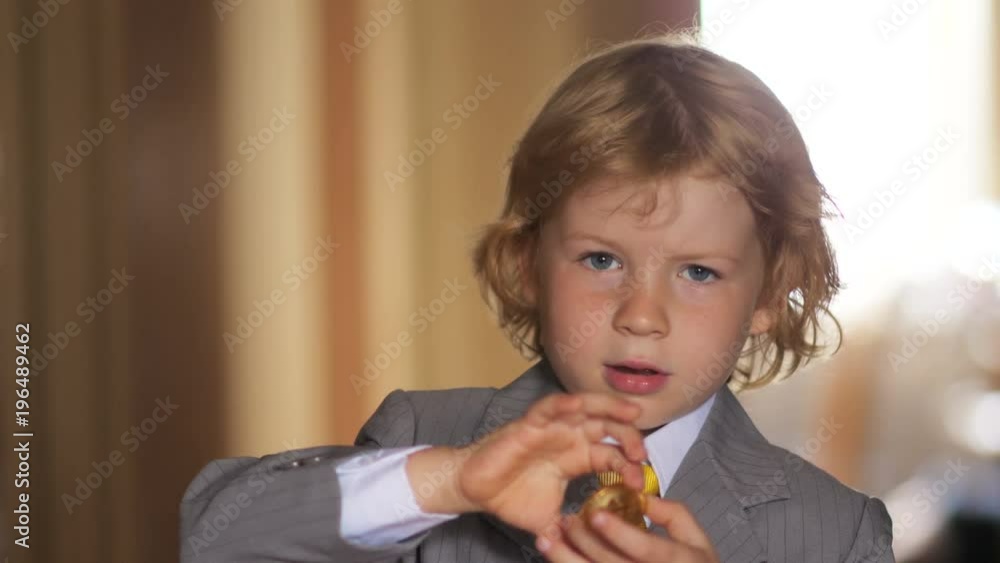 Young blonde boy in business dress playing with bitcoin coin. Young blonde boy in business dress playing with bitcoin coin.