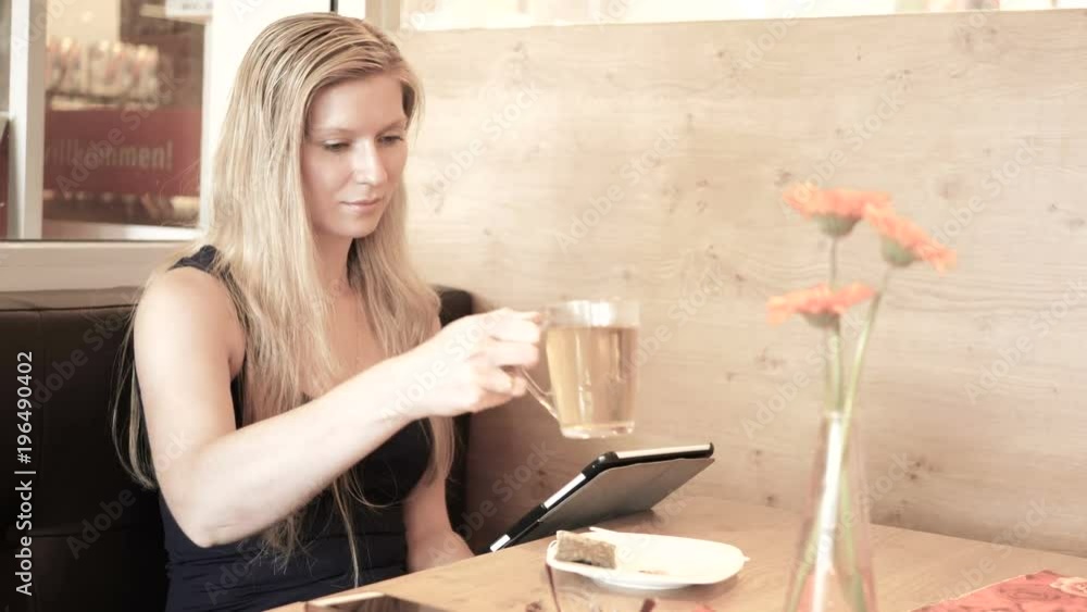 Young woman drinking tea at cafe and surfing the internet. Young woman drinking tea at cafe and surfing the internet.