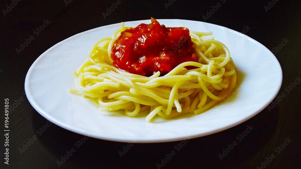 Delicious pasta with vegetables in white plate on black background. Delicious pasta with vegetables in white plate on black background.