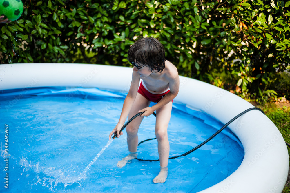 Children Having Fun In Garden Paddling Pool