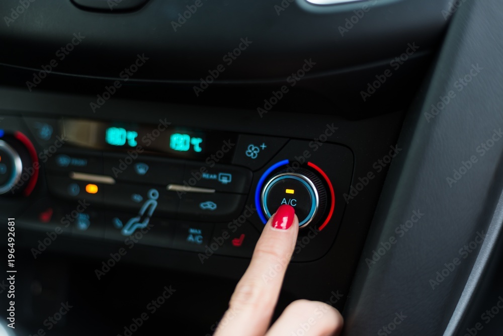 Woman turning on car air condition.
