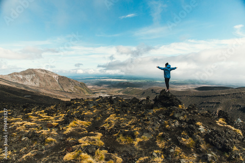 One girl standing at the top watching volcanic valley enjoying the view
