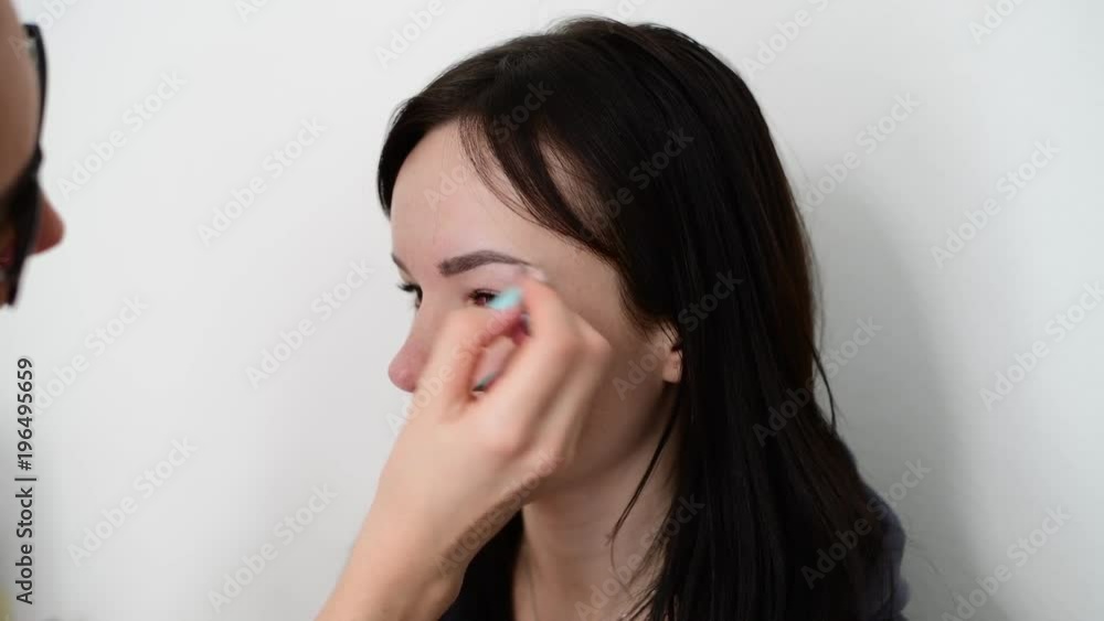 visagiste paints eyebrows young dark-haired girls visagiste paints eyebrows young dark-haired girls