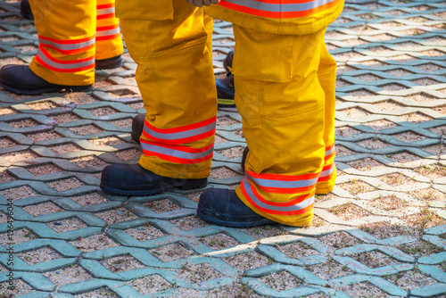 fireman standing in row with fire fighting protection suit and equipment standby for operation