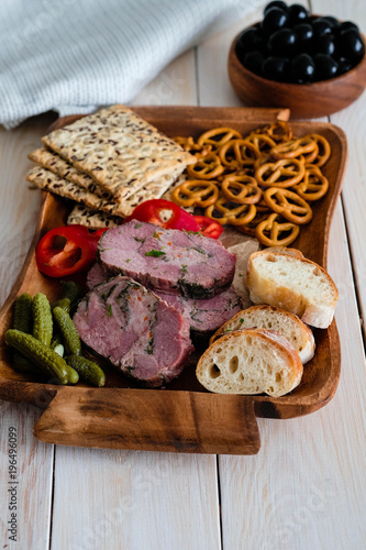 Antipasti and catering platter with different meat and bread products.
